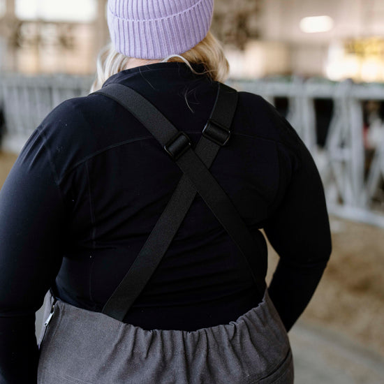 Person in purple toque with grey overalls on