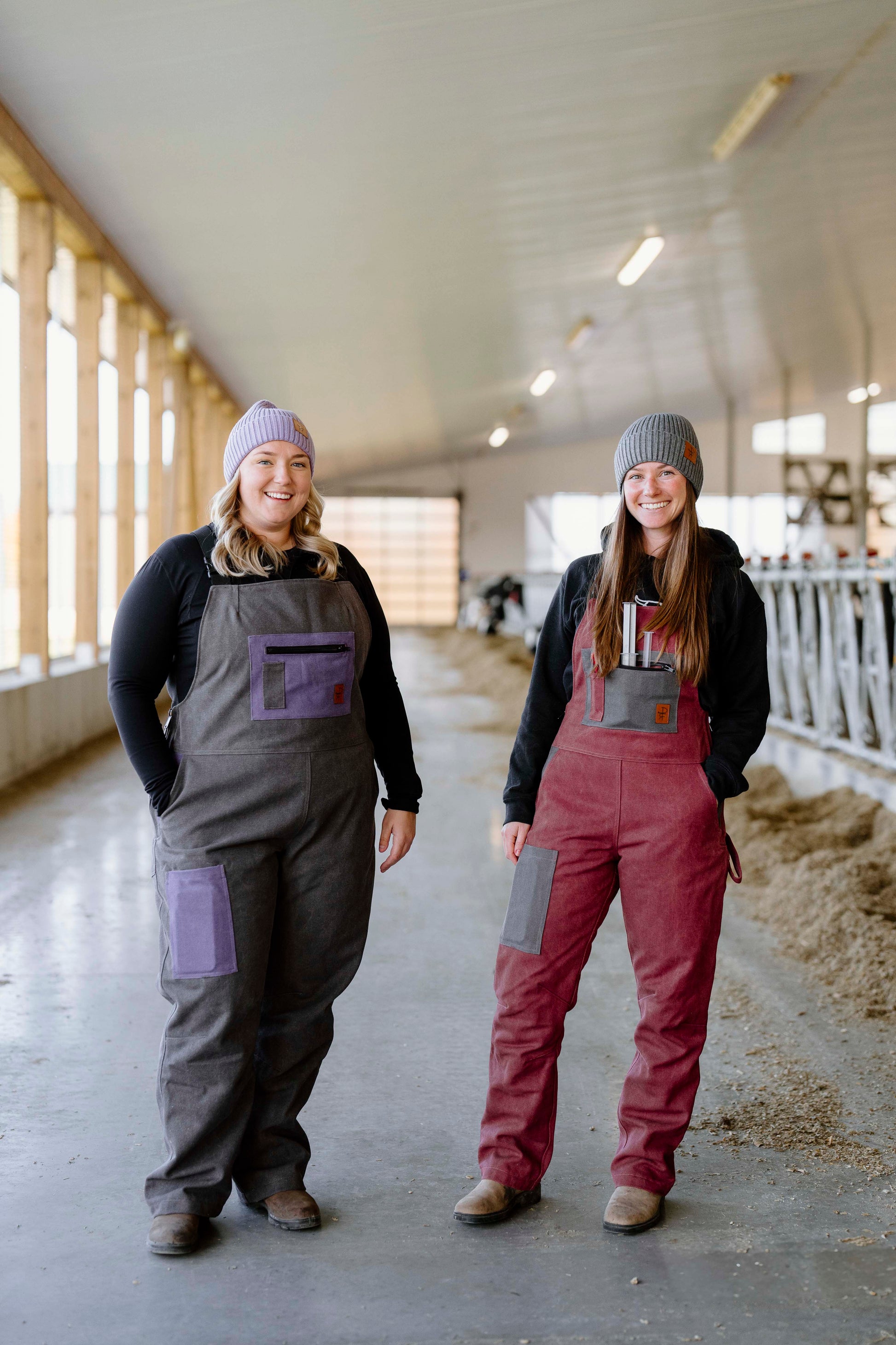 person wearing grey overalls with purple pockets beside other person wearing pink overalls with grey pockets 