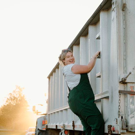 Person climbing into a large white truck on a sunny day