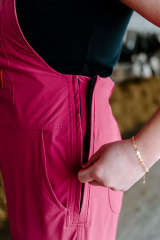 Person wearing pink overalls with a blurred background