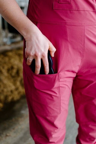 Person wearing pink overalls with a blurred background