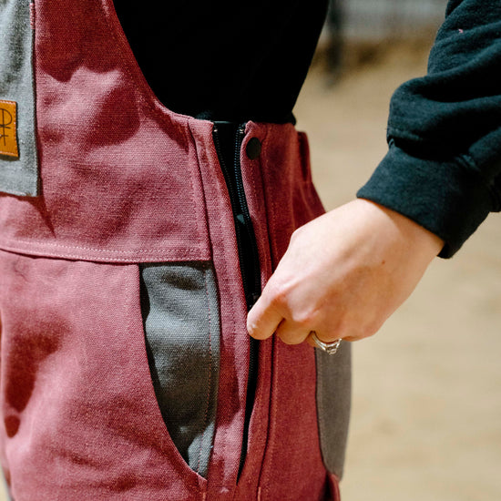 Close-up of a person wearing pink overalls with a blurred background