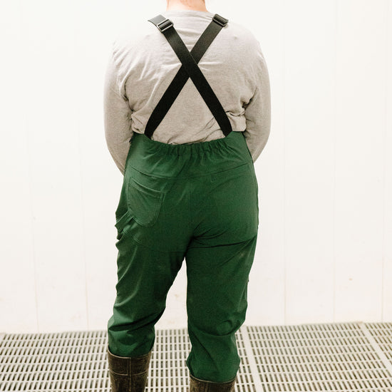 Lady wearing dark green overalls with rubber boots