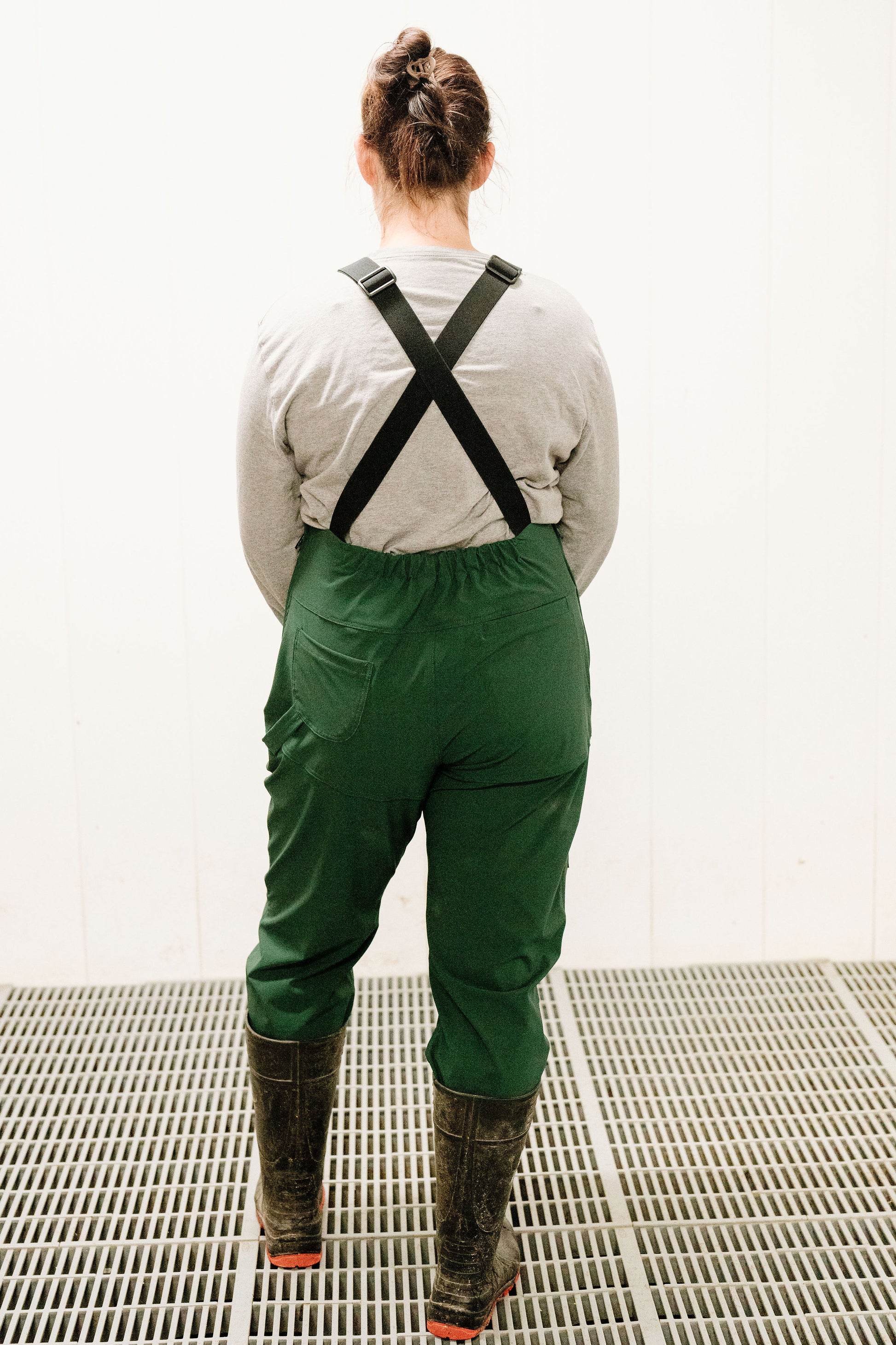 Lady wearing dark green overalls with rubber boots